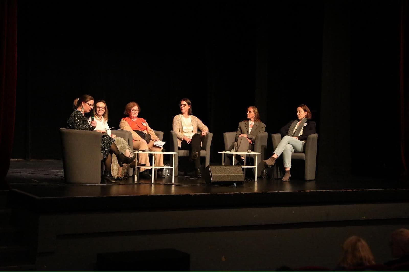 Un groupe échange sur scène lors d'une rencontre publique organisée par Odysée
